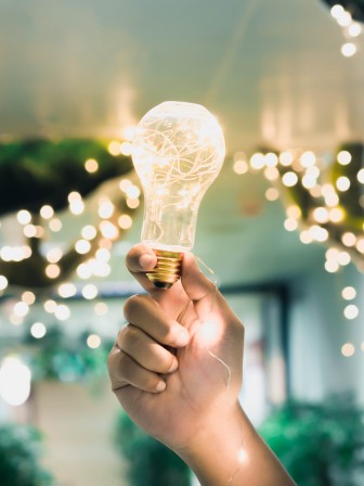 Hand holding a glowing light bulb